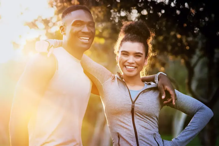 Couple in exercise clothing standing together outdoors after a workout