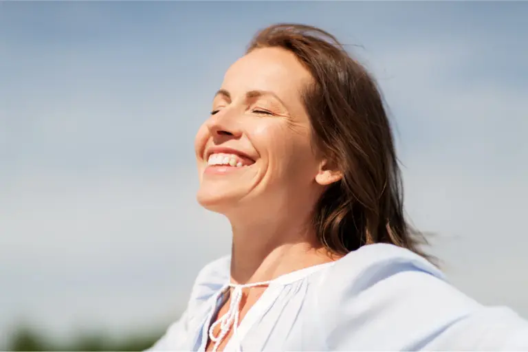 Woman smiling with her eyes closed and her face turned to the sun