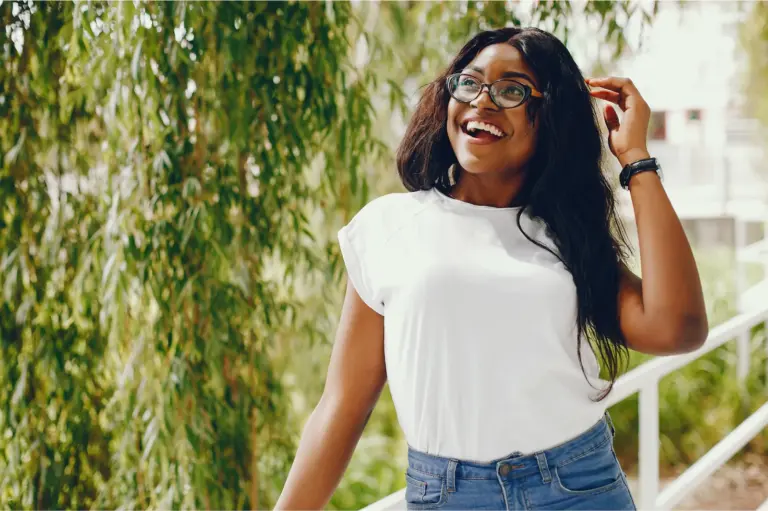 Woman in glasses laughing outdoors on a summer day